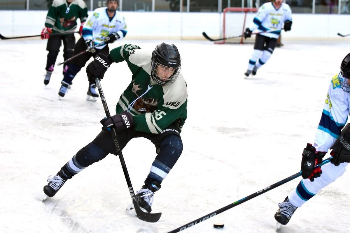 Hockey player skating with the puck on the ice